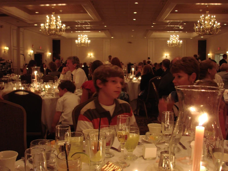 a  is sitting at a restaurant table surrounded by glasses and wine