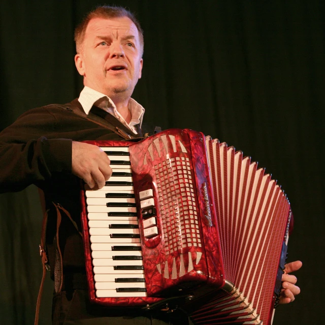 the man is holding an accordion in his hands