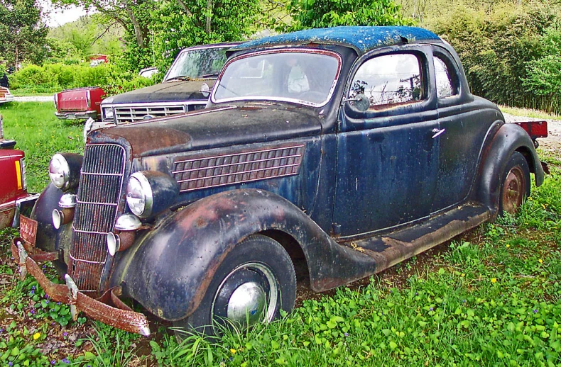 an antique truck is parked in the grass