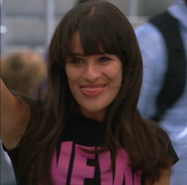 the young woman smiles for the camera in her pink shirt