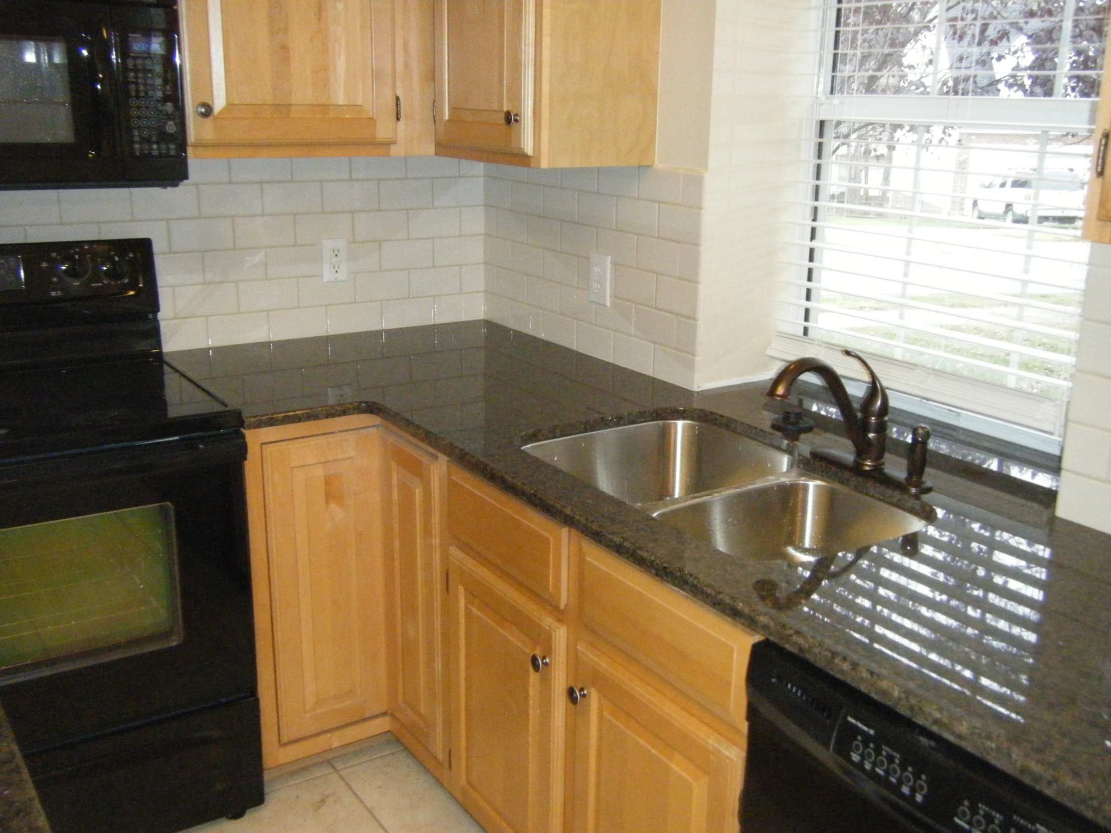 the kitchen has wood cabinets and granite counter tops