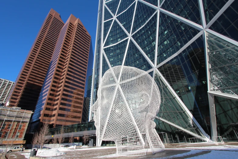 a large sculpture is next to other tall buildings