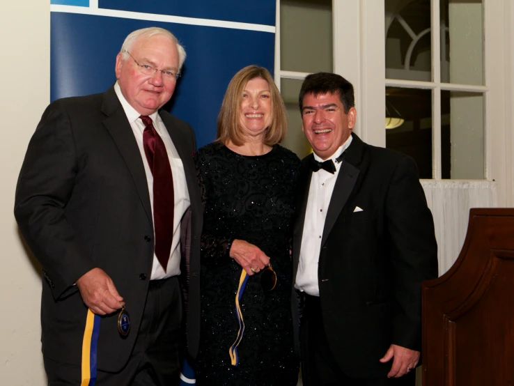 two men and one woman wearing suits and ties