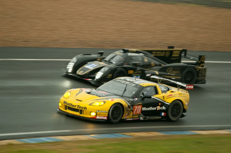 two yellow and black racing cars rounding a turn