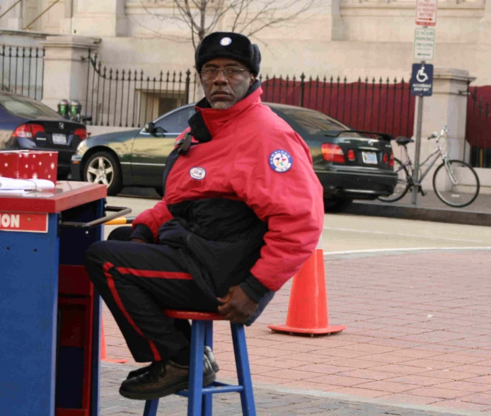 a man sitting on a blue and red stool