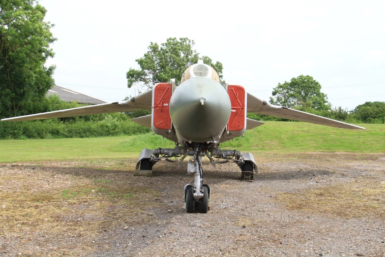 there is a red and white plane parked in the middle of a field