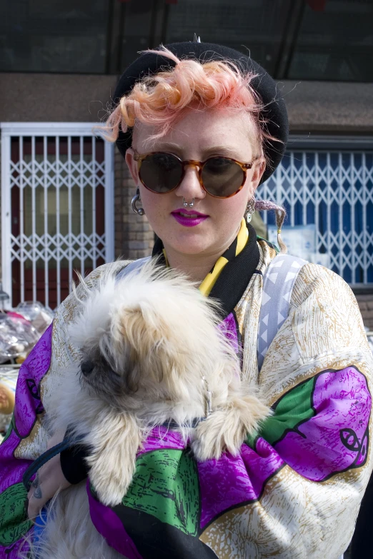 the woman is holding her dog while wearing a costume