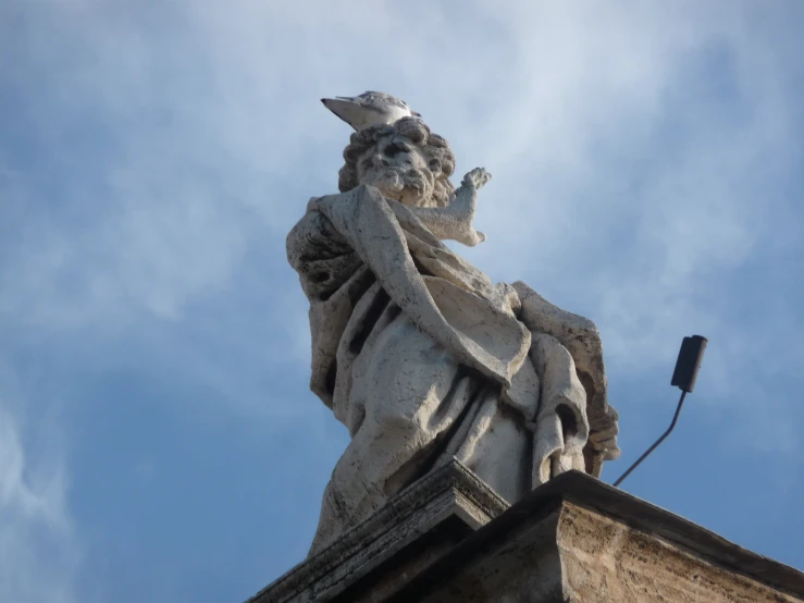 an odd statue of a man holding a small bird