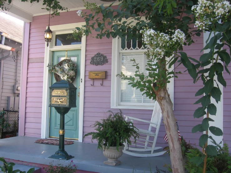 front porch with pink painted house and rocking chair