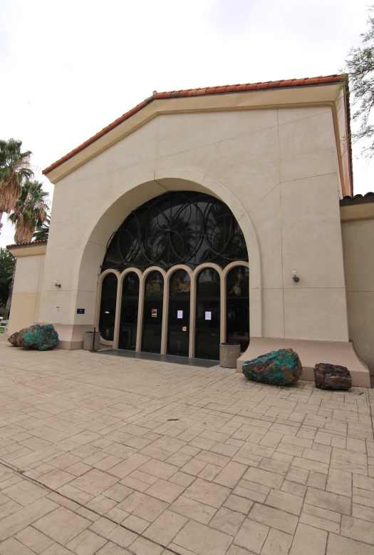 the doors of an entryway to a museum with sculptures outside