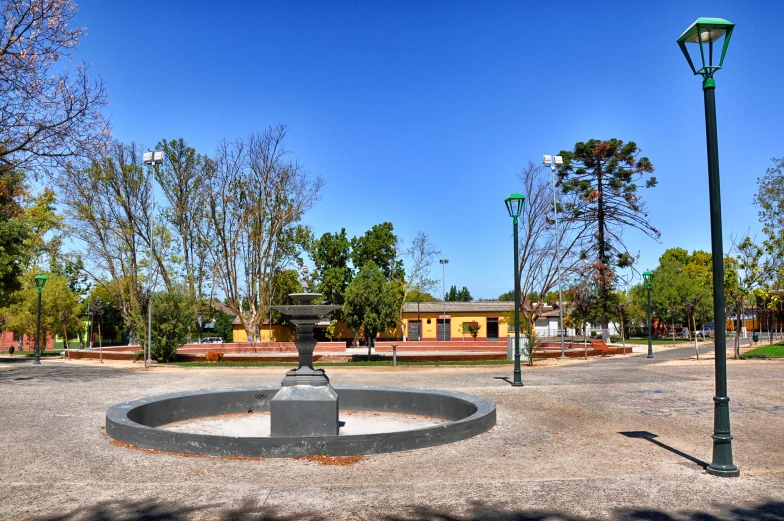 there is a park with light poles and a fountain