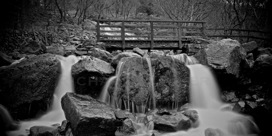 a long exposure of water coming down rocks into a small waterfall