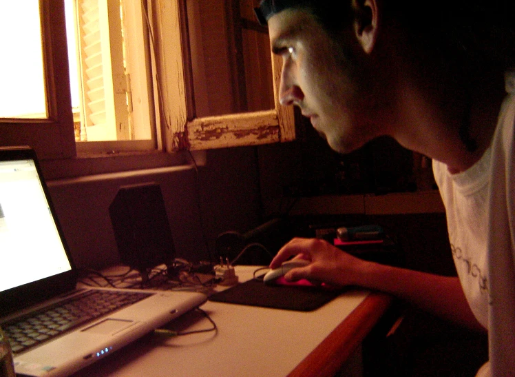 a young man is looking at his computer screen