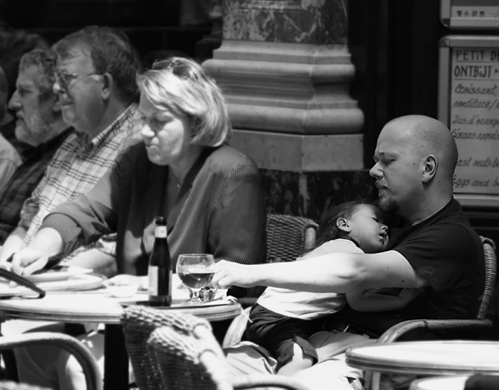 three adults and a baby sit around a table