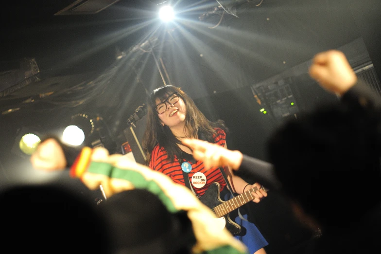 a person standing up on stage with a guitar