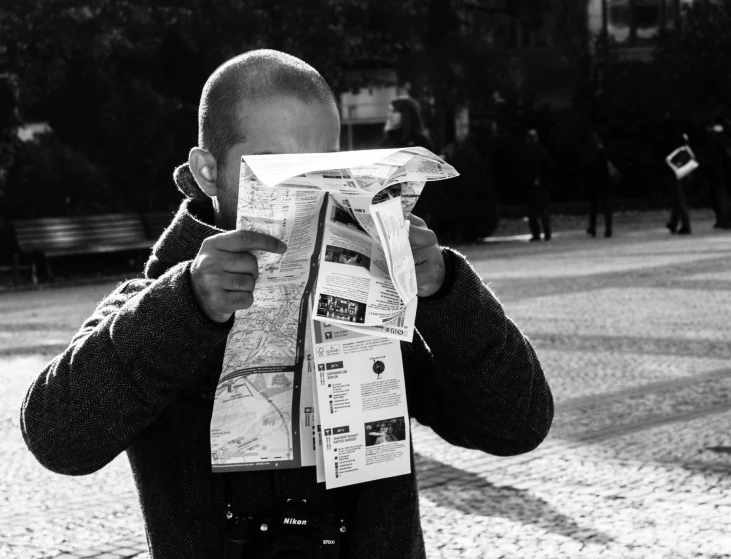 a man reading the paper while covering his face