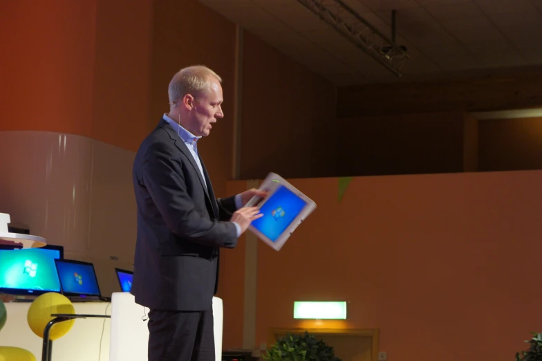 a man with a blue tablet in front of people