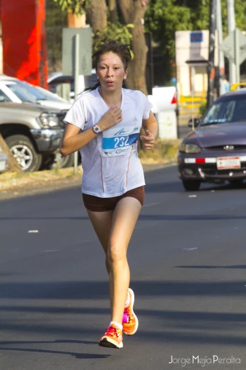 a woman jogging down the street in a shirt and shorts