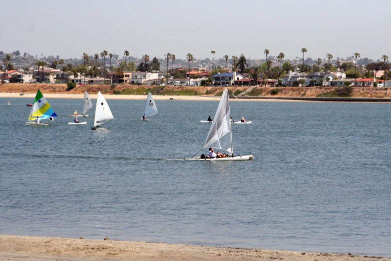 several small boats sailing on a large body of water