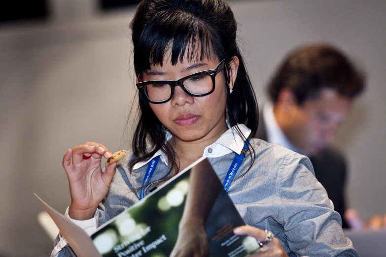 the woman is holding an article of news magazine