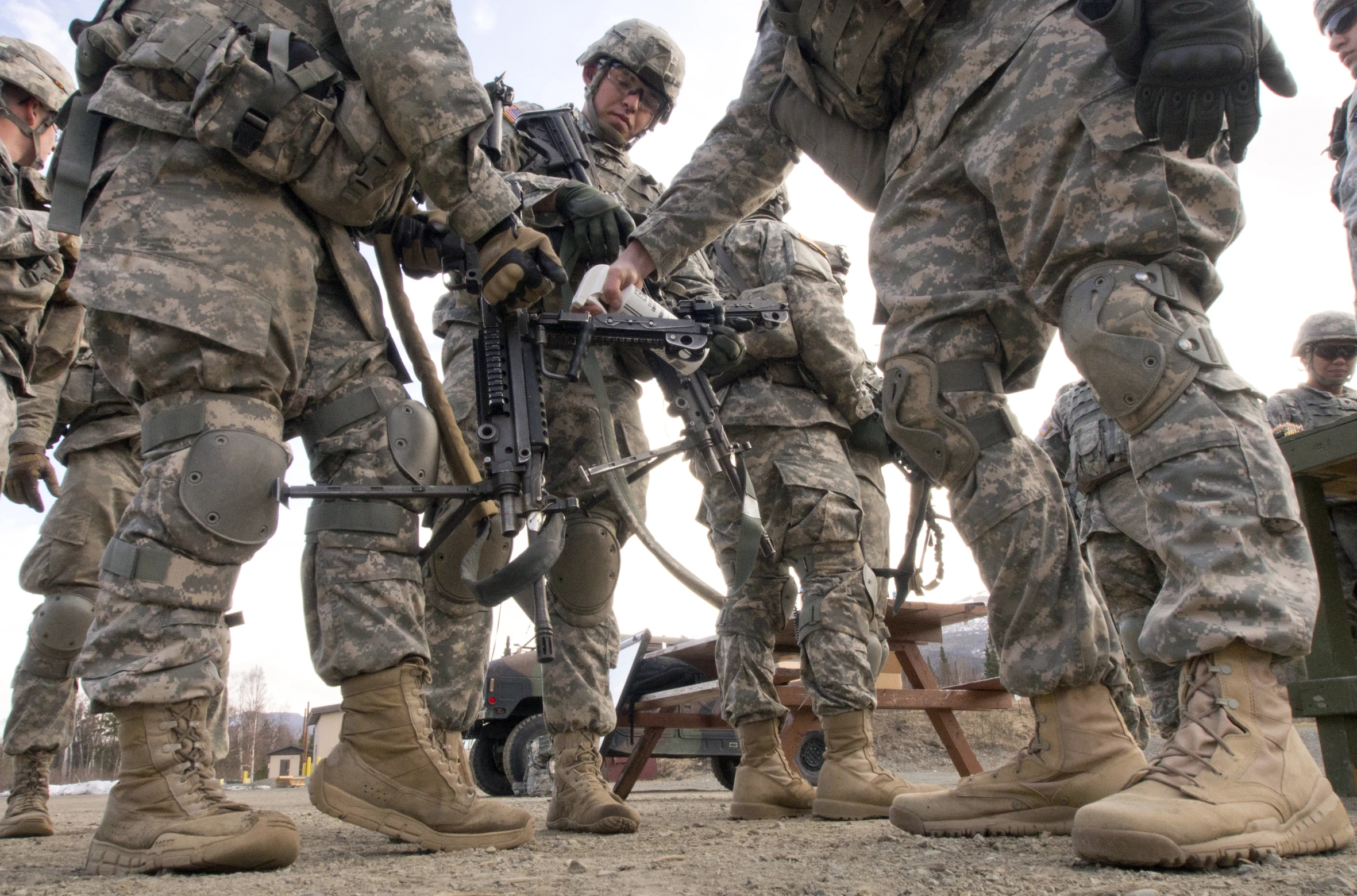 army men in uniform and their arms around an old machine