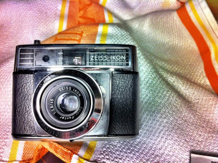 an old camera sitting on a towel
