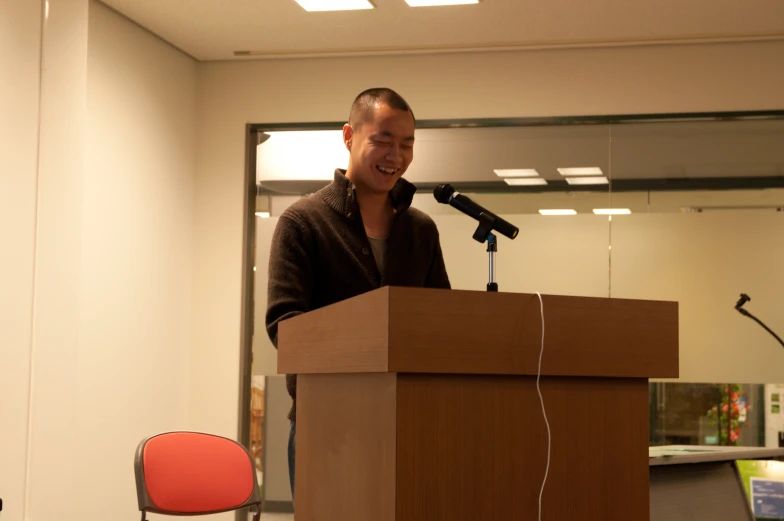 a man standing at a podium in front of a microphone