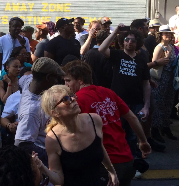 group of people gathered around each other on a sidewalk