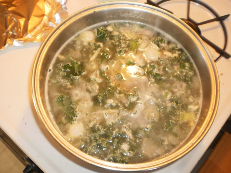 a pot with broccoli and chicken in it is on the stove