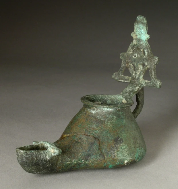 a small vase with a man riding on top of it