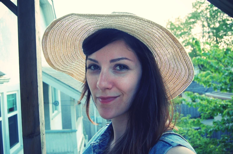 woman in hat posing for camera on the porch