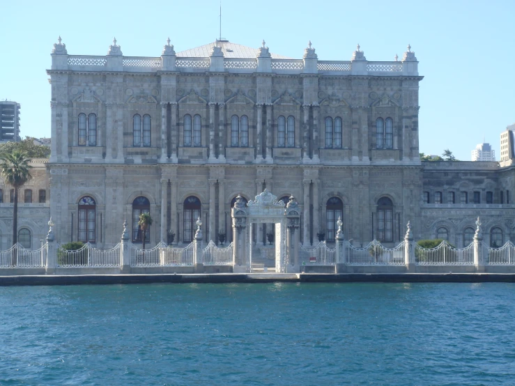 an elaborate building sitting on the edge of a lake