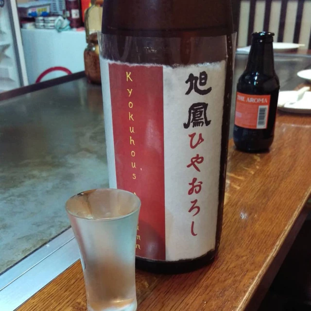 a large bottle of alcohol and a glass on a table