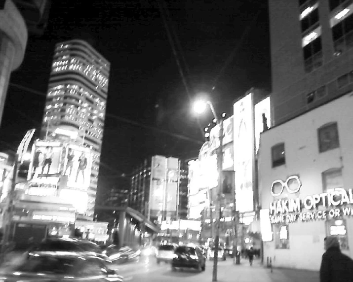 a city street at night with lots of lights and people