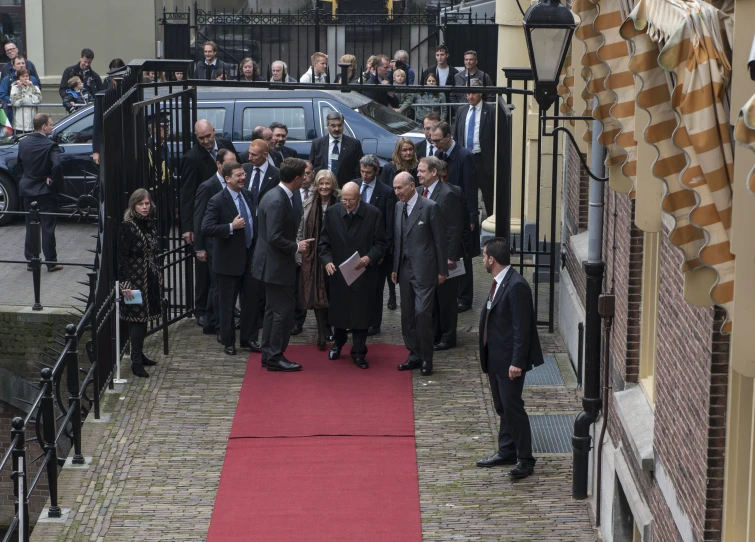 a group of men standing on a red carpet