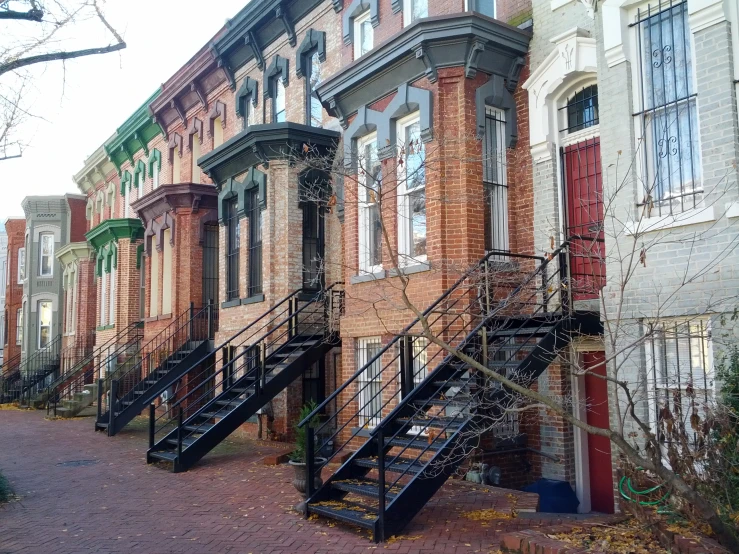 an old brick apartment building has metal stairs leading up to it