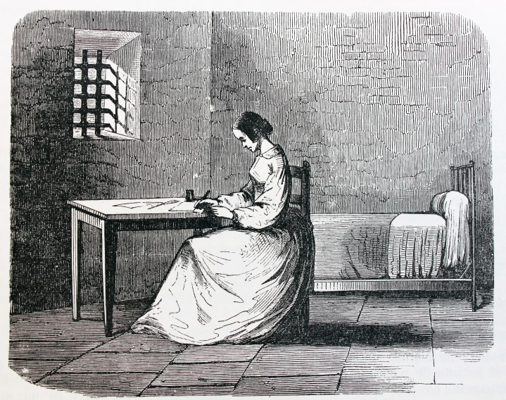 an old image of a woman writing at a table