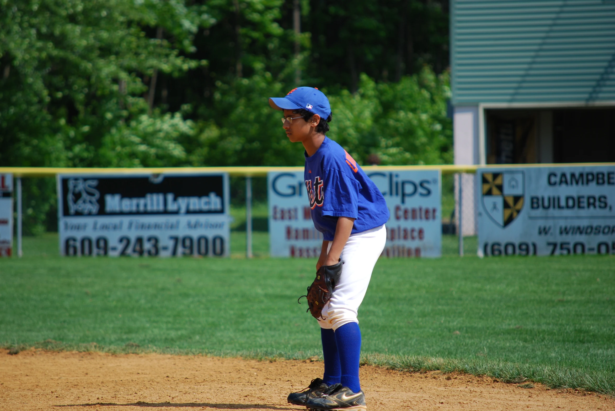 the child is waiting on the mound for the ball