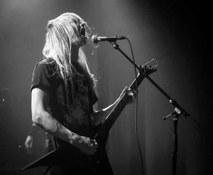 a black and white po of a person playing guitar on stage