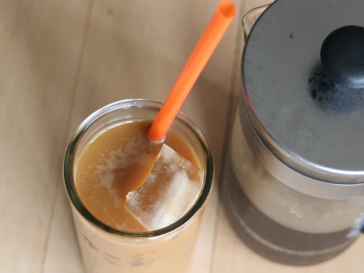 a glass jar with a spoon and drink in it