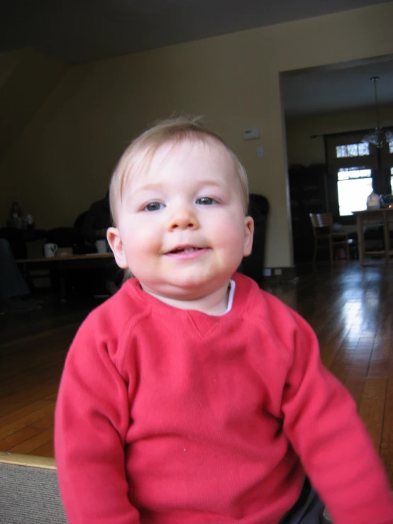 a young baby is sitting down in the living room