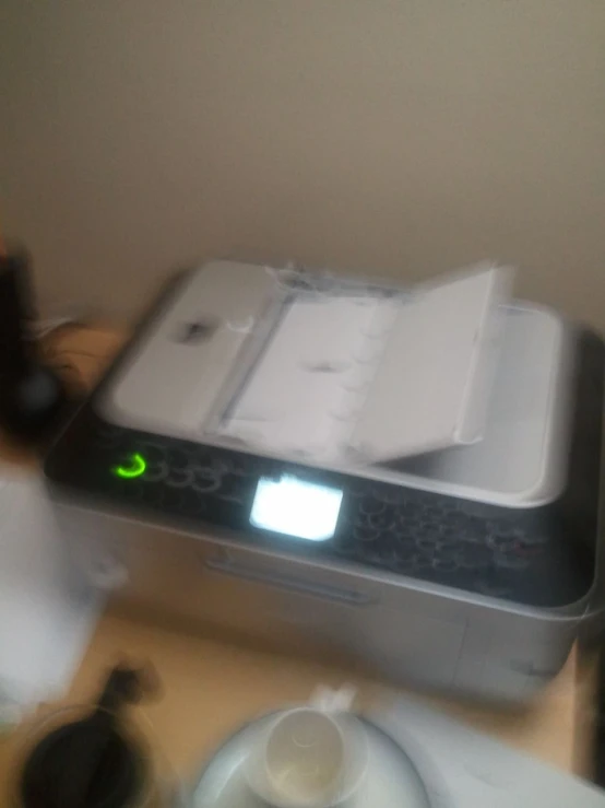 a printer on a table with its backlit, next to an apple