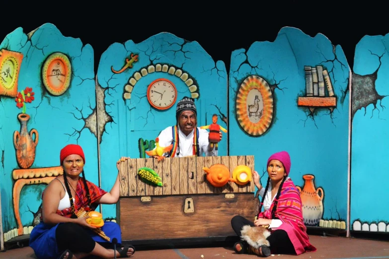 two people on stage with blue backdrop with a man in a pirate costume holding a wooden chest