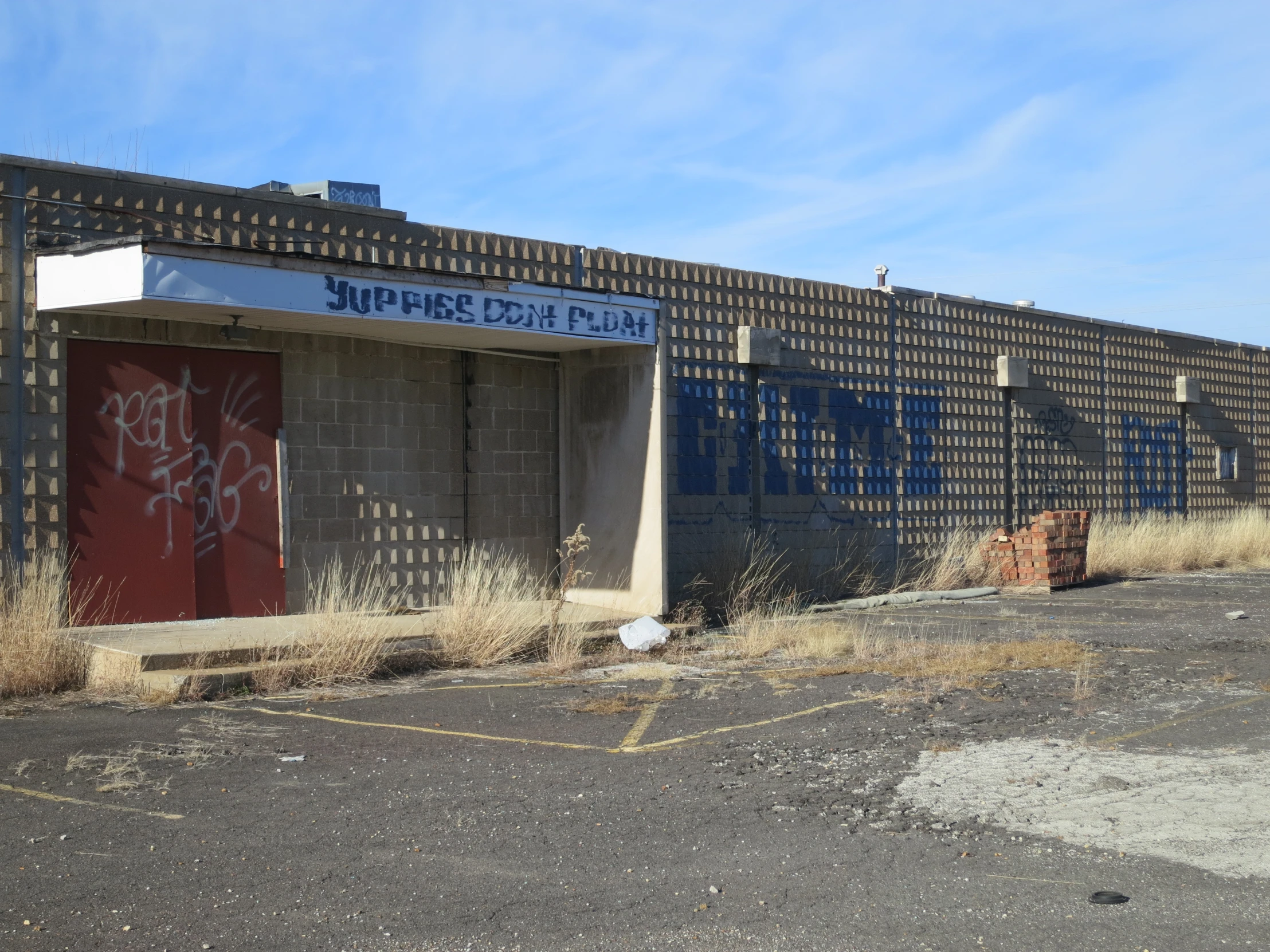 an empty parking lot with an old building covered in graffiti