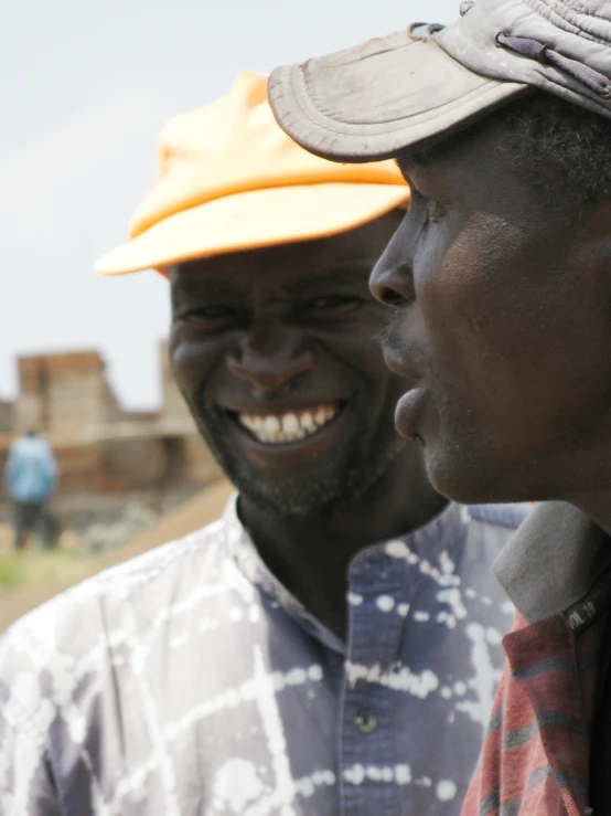 a man is laughing and wearing a hat