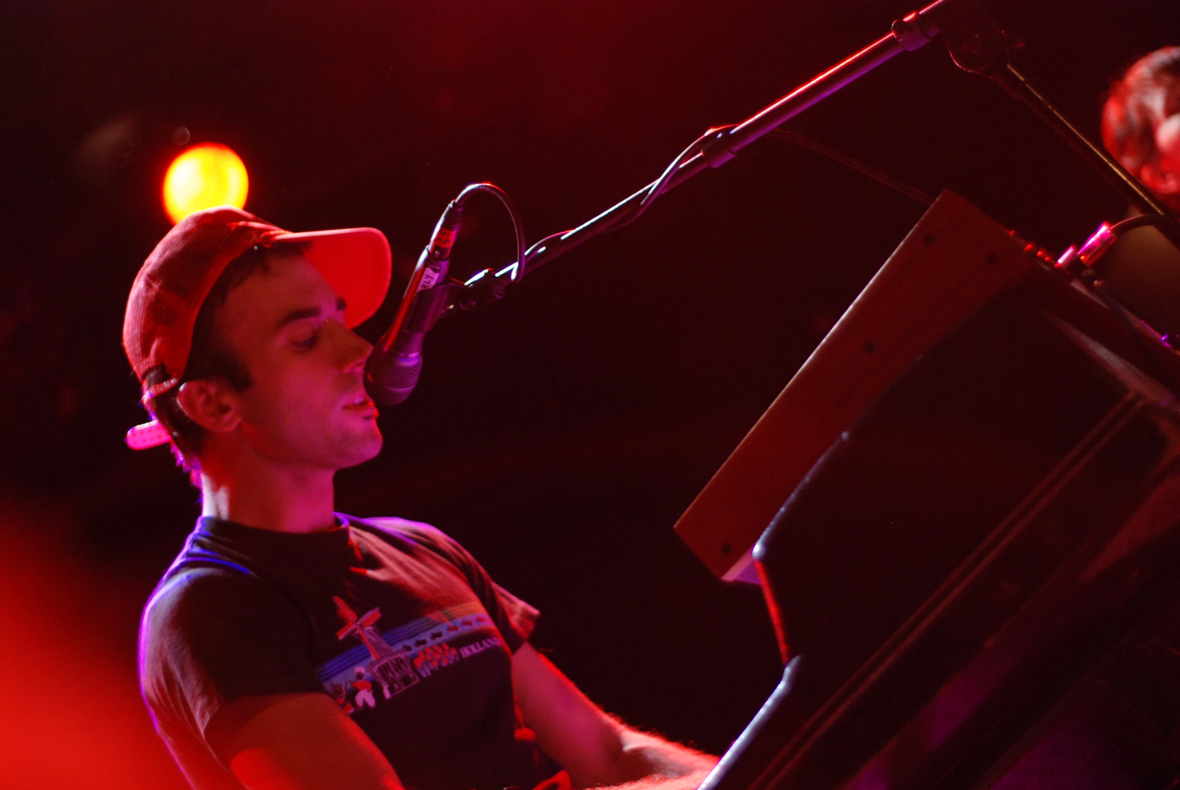 a male in black shirt and hat playing keyboard