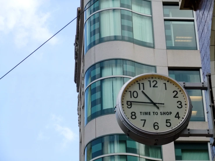 a white clock attached to the side of a building