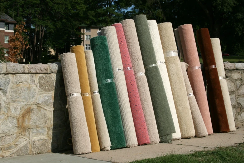 a line of towels sit outside against a stone wall