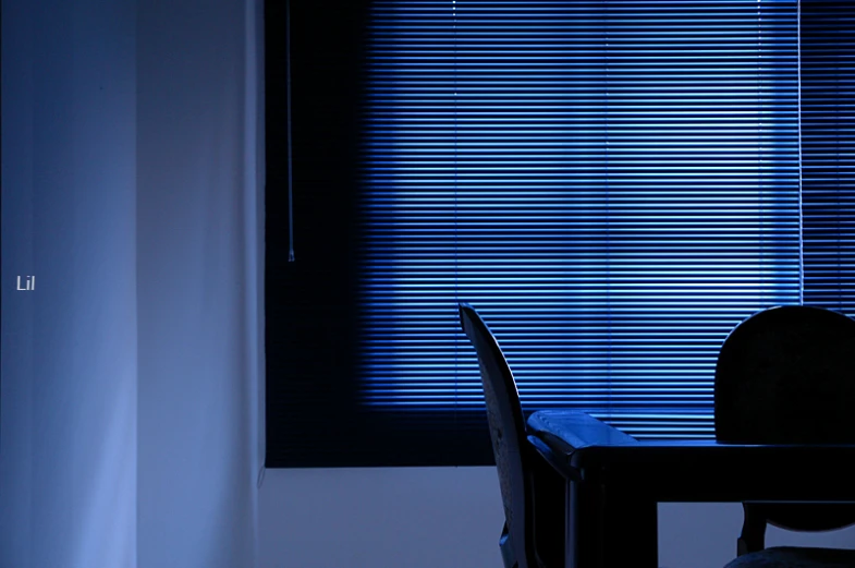 a table and chairs in front of window with a blue blind