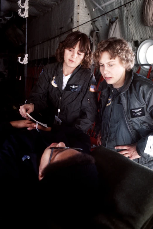 two people in black coats look at a cellphone